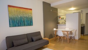 A modern living room with a grey sofa, a white rug, and a painting on the wall. - Borges Apartment by Be Local Argentina (Buenos Aires)