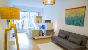 A modern living room with a grey sofa, white rug, and a painting on the wall. - Borges Apartment by Be Local Argentina (Buenos Aires)