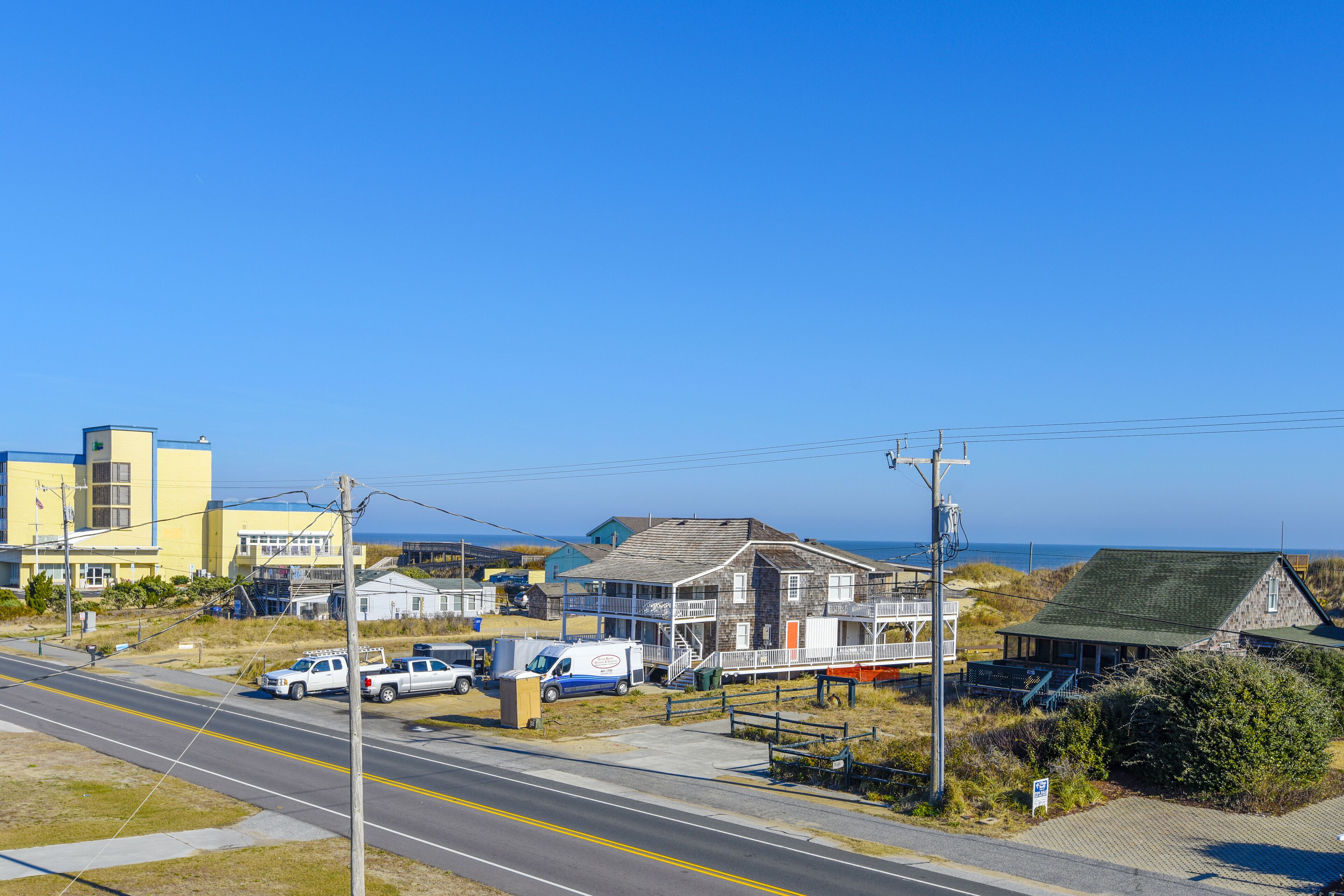 A coastal town with a prominent building featuring a balcony and a small dock.
