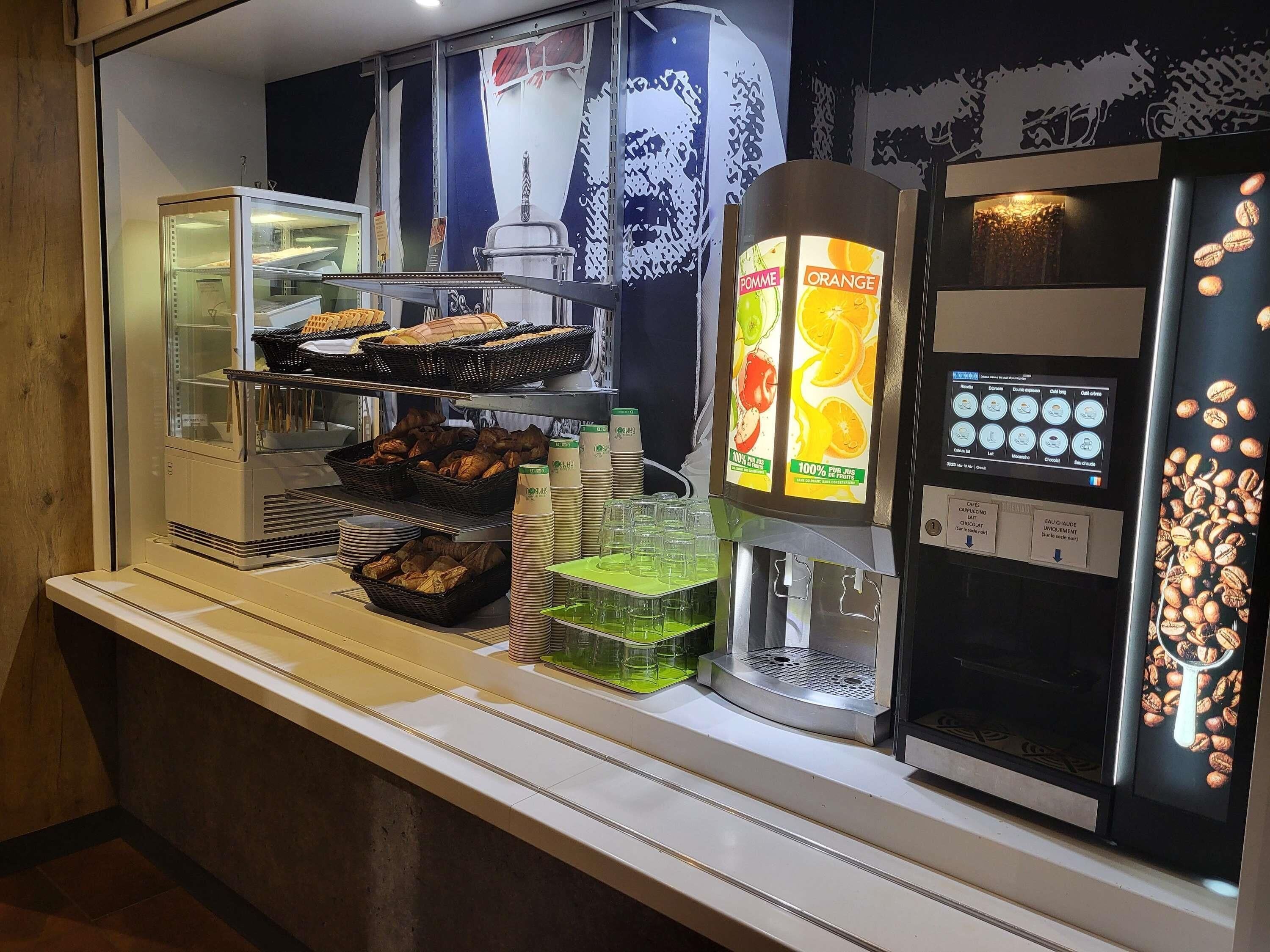 A breakfast bar with pastries, coffee options, and a coffee machine.