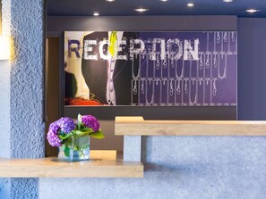 Un mostrador de recepción con un cartel de pizarra que dice "RECEPTION" y "FASHION".