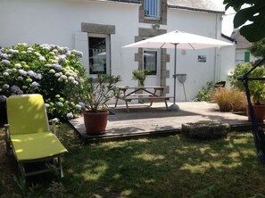 A patio with a wooden table and chairs, surrounded by potted plants and a yellow chair. - House / Villa - Guérande (Guérande)
