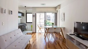 Eine moderne Wohnung mit Wohnbereich, Essbereich, Küchenzeile und einem Balkon mit Stadtblick.