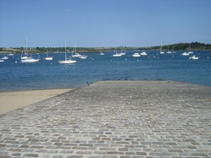 A stone-paved waterfront with several boats anchored in the water. - Cottage 100 meters from the beach (Le Minihic-Sur-Rance)