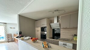 A modern kitchen with a wooden countertop, a bowl of fruit, a toaster, and a dishwasher. - Ste Maxime F3/65m², 2-7 pers, air-conditioned, garage, WiFi, swimming pool (Sainte-Maxime)