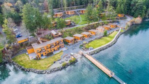 A lodge with multiple cabins, a dock, and a surrounding forest. - Snug Harbor Resort (Friday Harbor)