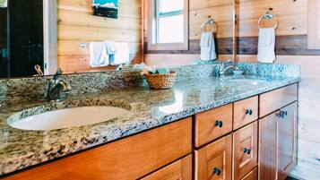 A wooden cabin-style bathroom with a granite countertop, a sink, and wooden cabinets.