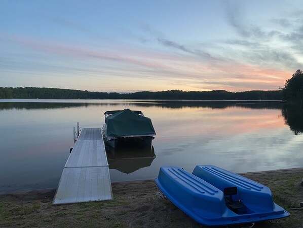 Ein ruhiger See mit einer Anlegestelle und einem Boot mit Verdeck.