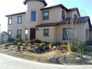 A two-story house with a curved corner, multiple windows, and a tiled roof.