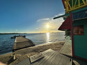 A wooden pier extending into calm waters, a clear sky, and a building with a Coca-Cola sign. - Your Perfect Starting Point for exploring the best of Boqueron, Cabo Rojo (Boquerón)