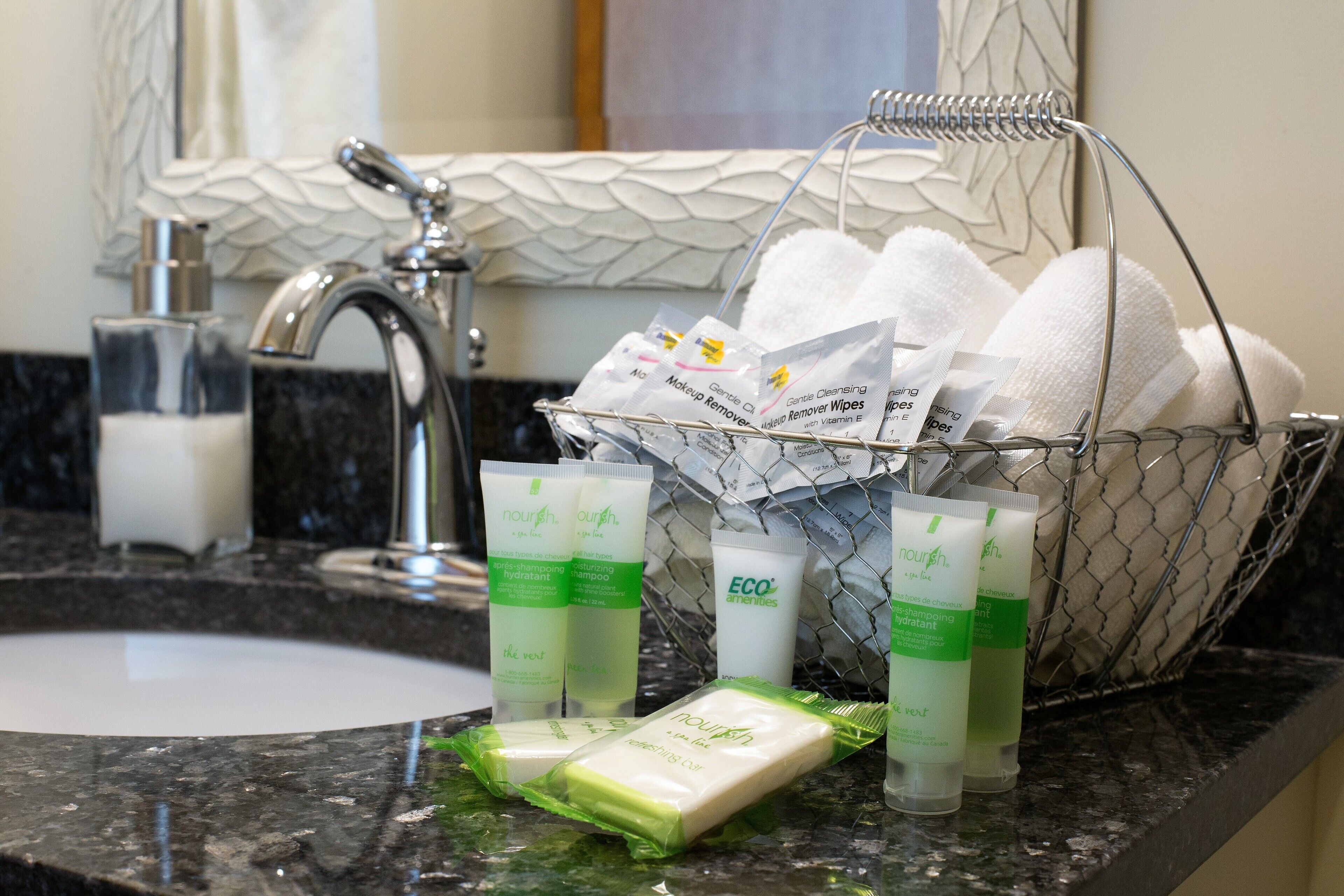 Toiletries including shampoo, conditioner, and makeup remover on a bathroom counter.