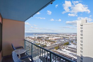 En balkon med udsigt over bybilledet, inklusive bygninger og et vandområde.