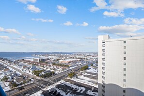 Ein Hochhaus mit Blick auf eine Küstenstadtlandschaft, einschließlich eines Yachthafens und Wohngebieten.