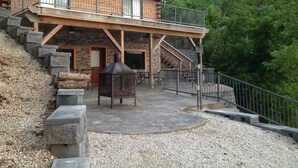 A rustic cabin with a stone exterior, a wooden deck, and a chimney. - Great lakefront Log Home  (Roach)