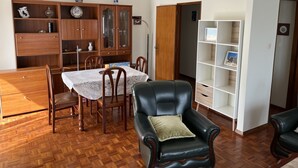 Un'area pranzo con un tavolo in legno, sedie e un mobile con ante in vetro.