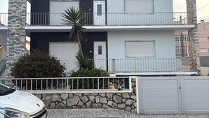 Un edificio a due piani con facciata in pietra, un balcone e un garage.