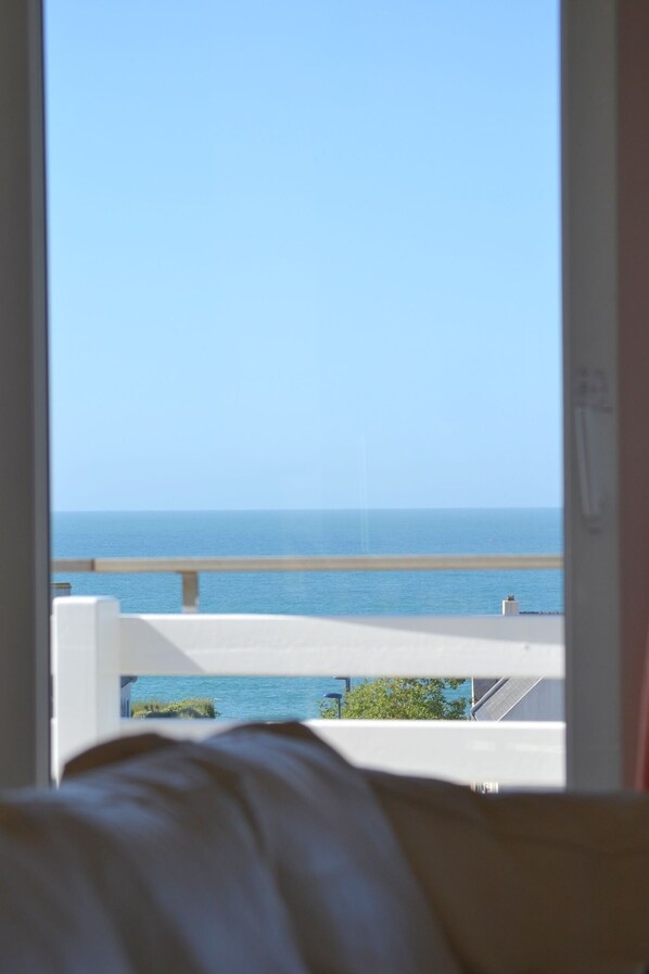 A room with a view of the sea through a window.