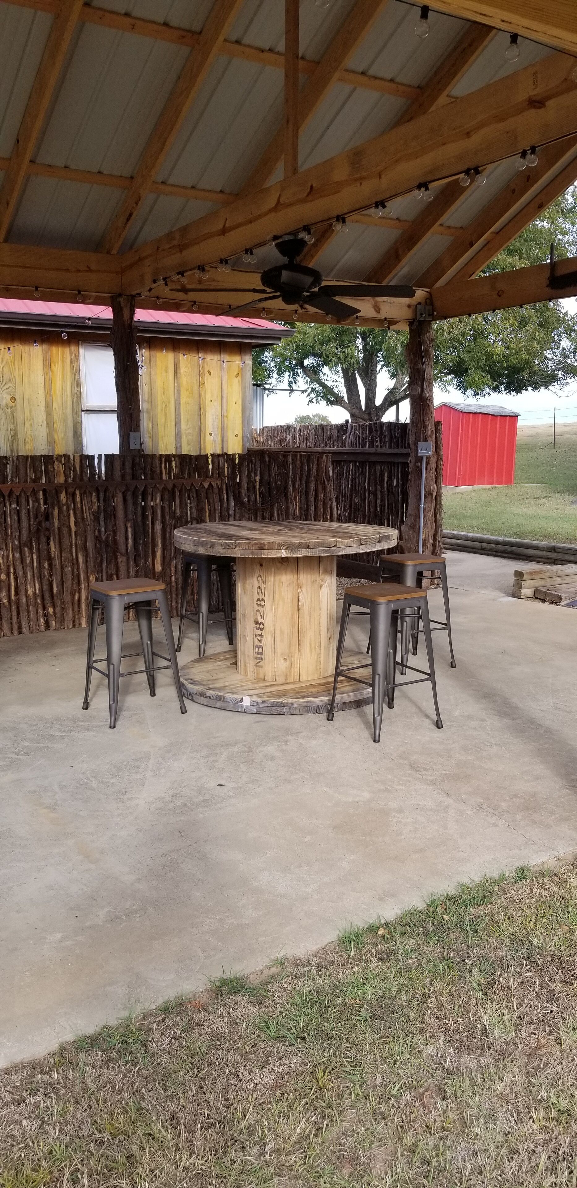 Hang out area under the pavilion with table and stools.