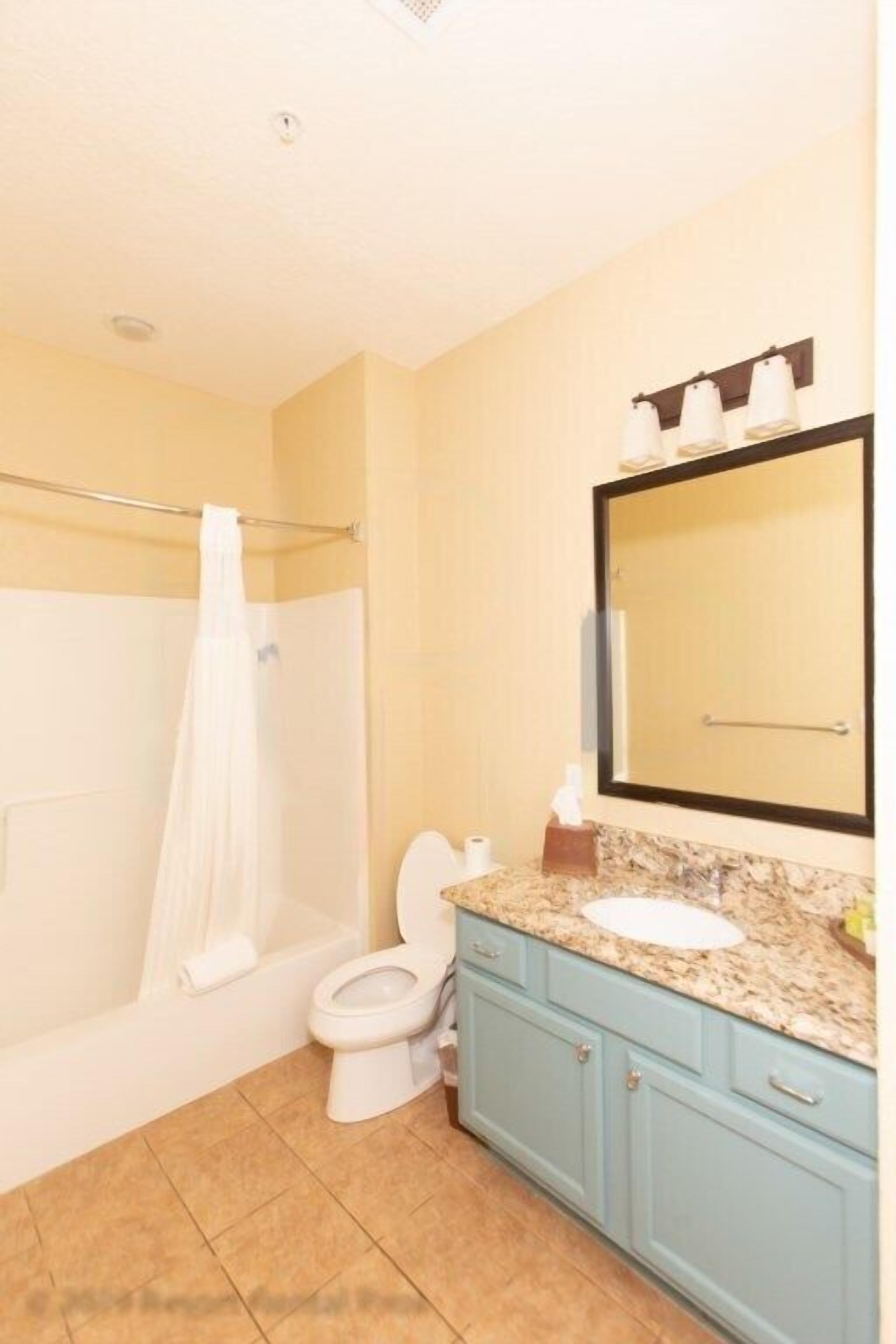 Un bagno con doccia, WC, lavandino e mobile lavabo.