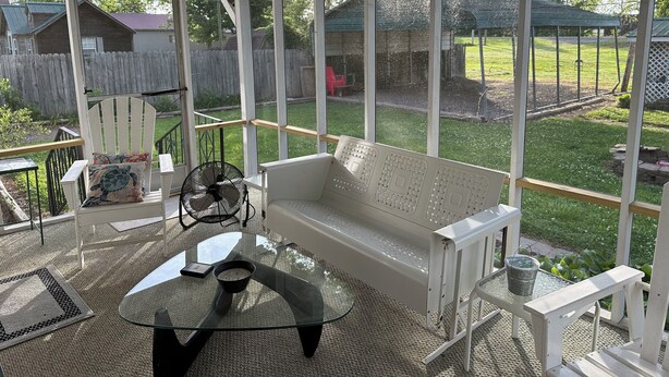 A covered patio with a white bench, a glass table, and a fan. - Fish cleaning station, screened porch, covered front porch, fire pit, 3 BR    (Hornbeak)
