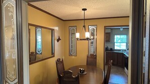 A dining room with a round table, chairs, and ornate mirrors on the walls. - Fish cleaning station, screened porch, covered front porch, fire pit, 3 BR    (Hornbeak)