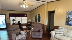 A living room with two armchairs, a sofa, a coffee table, and a ceiling fan. - Fish cleaning station, screened porch, covered front porch, fire pit, 3 BR    (Hornbeak)