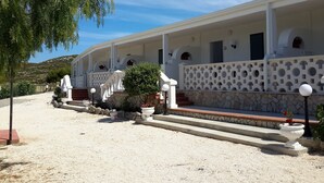 A white building with multiple balconies and a stone facade.