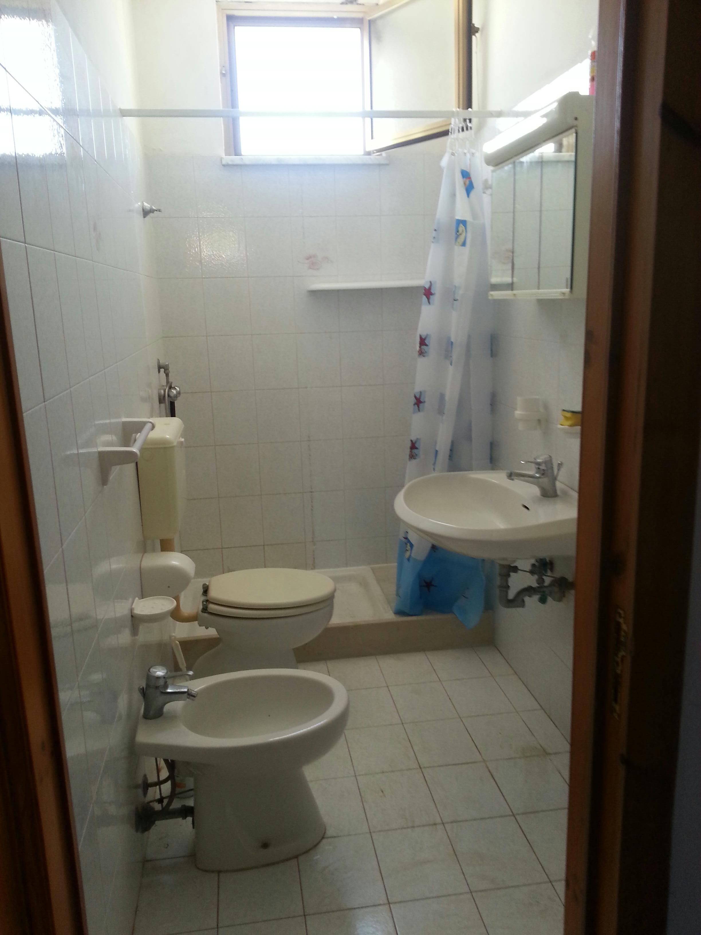 Een compacte badkamer met toilet, bidet en wastafel.