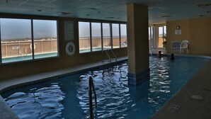 Ein Innenpool mit freiem Blick auf den Strand durch große Fenster.