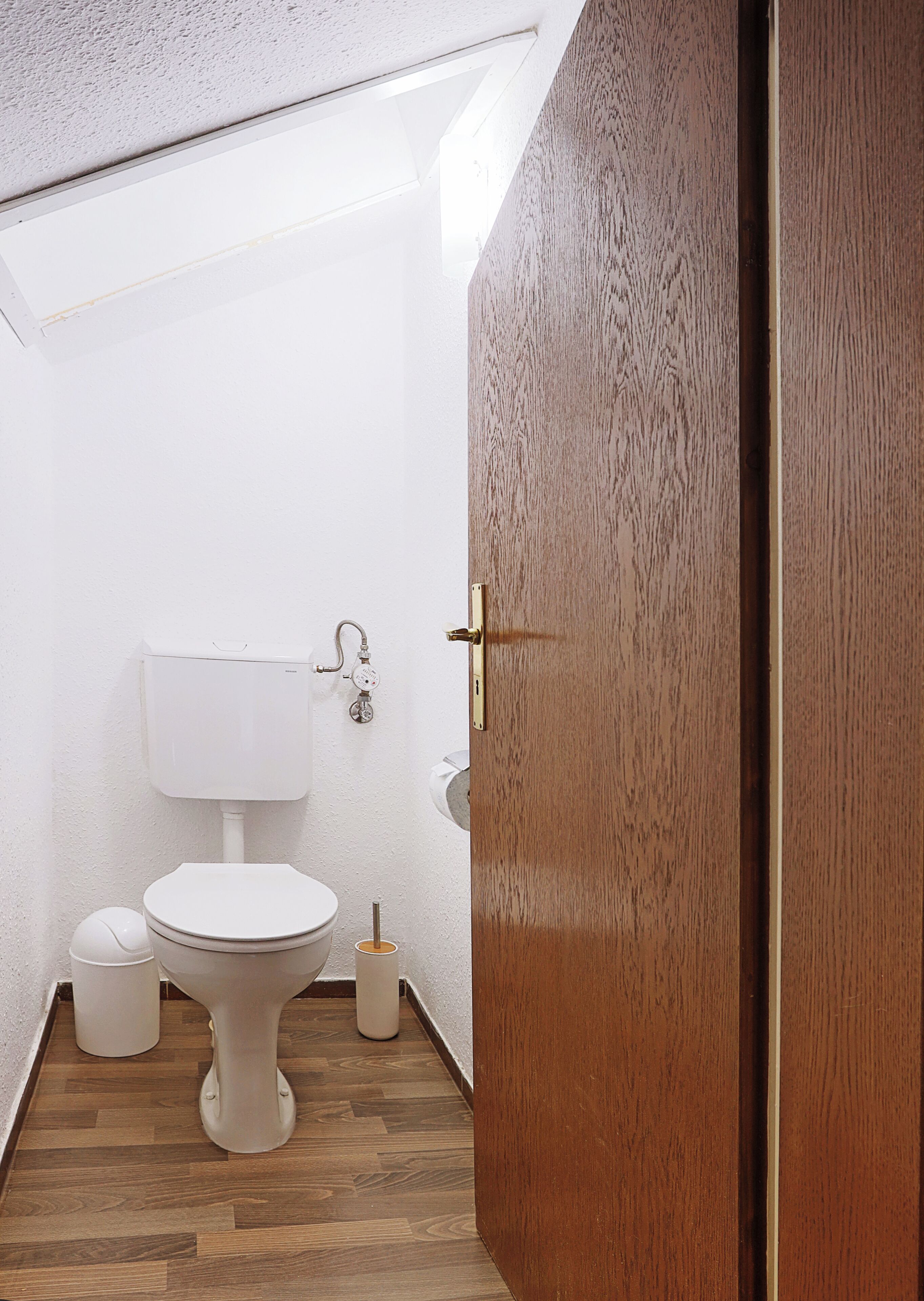 Un bagno piccolo con il water, un bidet e una porta in legno.