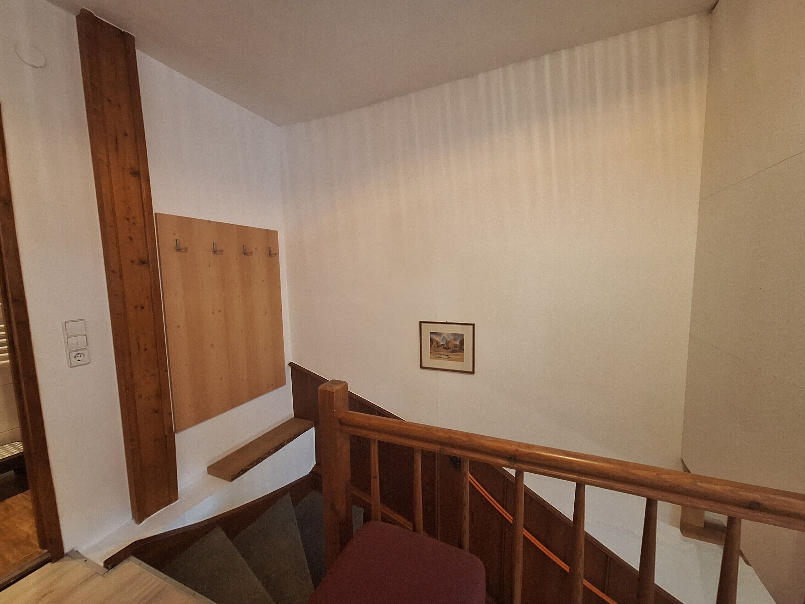 Een trap met houten leuningen en een wand van houten panelen.
