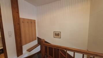 Een trap met houten leuningen en een wand van houten panelen.