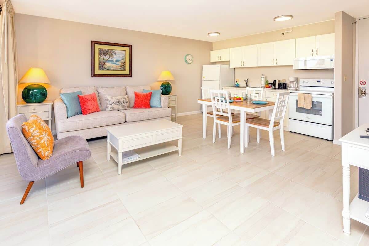 A modern living room with a sofa, coffee table, and dining table.