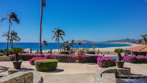 A resort with a pool area, palm trees, and a view of the beach and ocean. - Beachfront Paradise, right on the ocean! (San José Del Cabo)