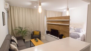 Een moderne woonkamer met een bank, een salontafel, een televisie en een open haard.