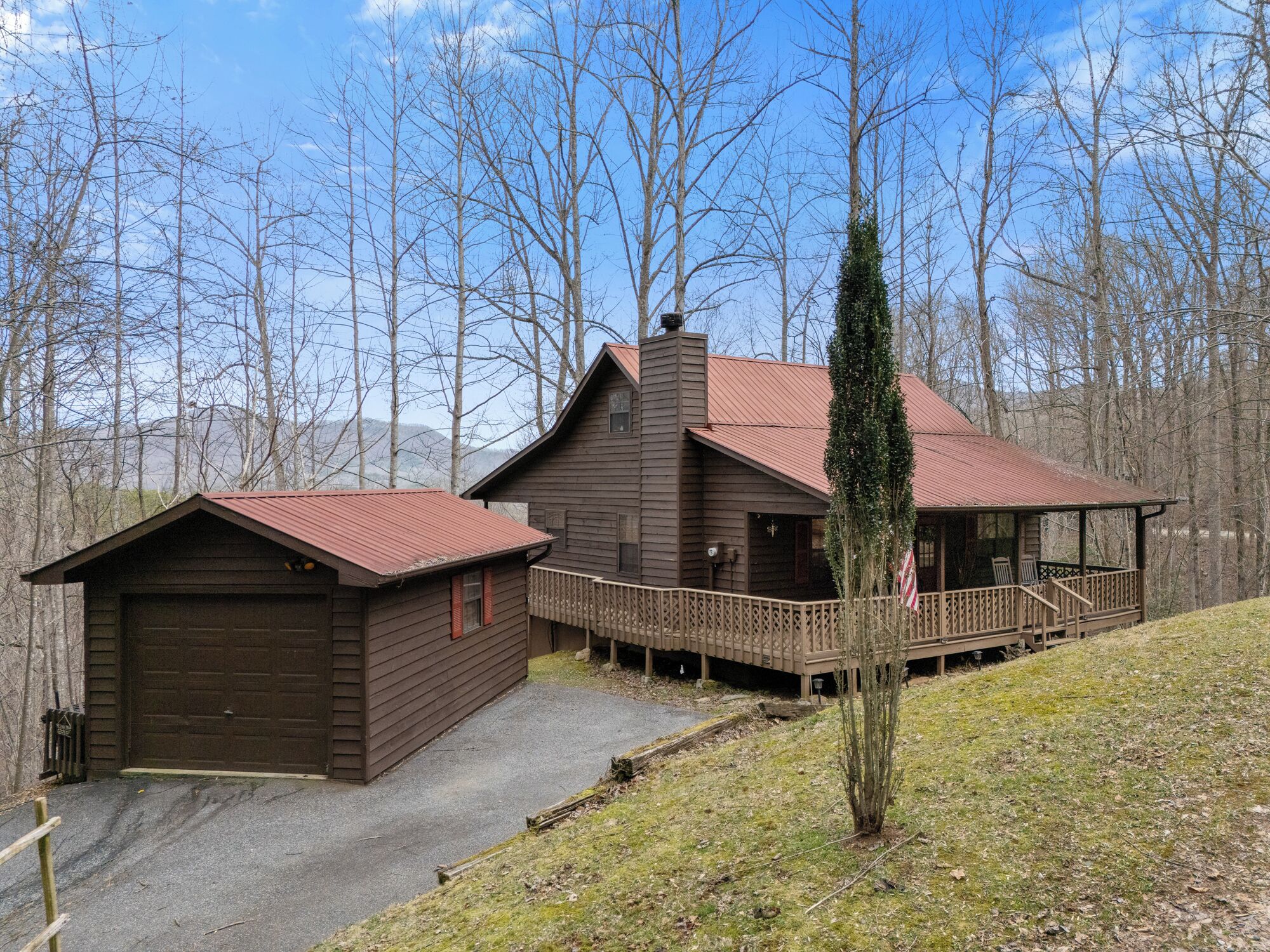 Eine rustikale Holzhütte mit Veranda und Garage.
