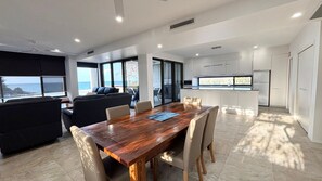 A modern interior with a dining area, a sofa, and a kitchen. - Waterford Apartment 3 - Bring your own linen (South West Rocks)