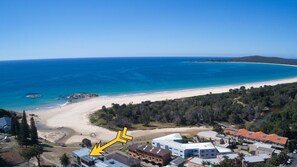 Una zona costera con playa, edificios residenciales y una vista despejada del océano.