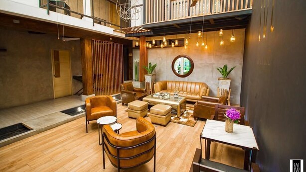 Ein modernes Interieur mit hohen Decken, Holzböden, Ledersofas und einem Essbereich.