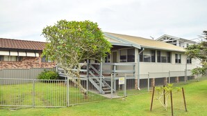 A two-story building with a covered porch and a fenced backyard. - Sunshine Cottage - walk to the beach - Bring your own linen (SOUTH WEST ROCKS)