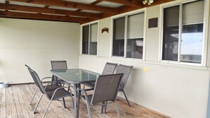 Relax in this serene outdoor seating area with a glass-top table and six comfortable chairs.