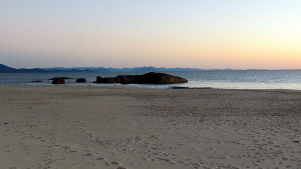 Una playa con rocas grandes y un mar tranquilo.