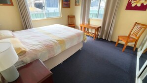 A hotel room with a bed, a desk, a chair, and a window. - Wenlaw Cottage (Rear) Hat Head (HAT HEAD)