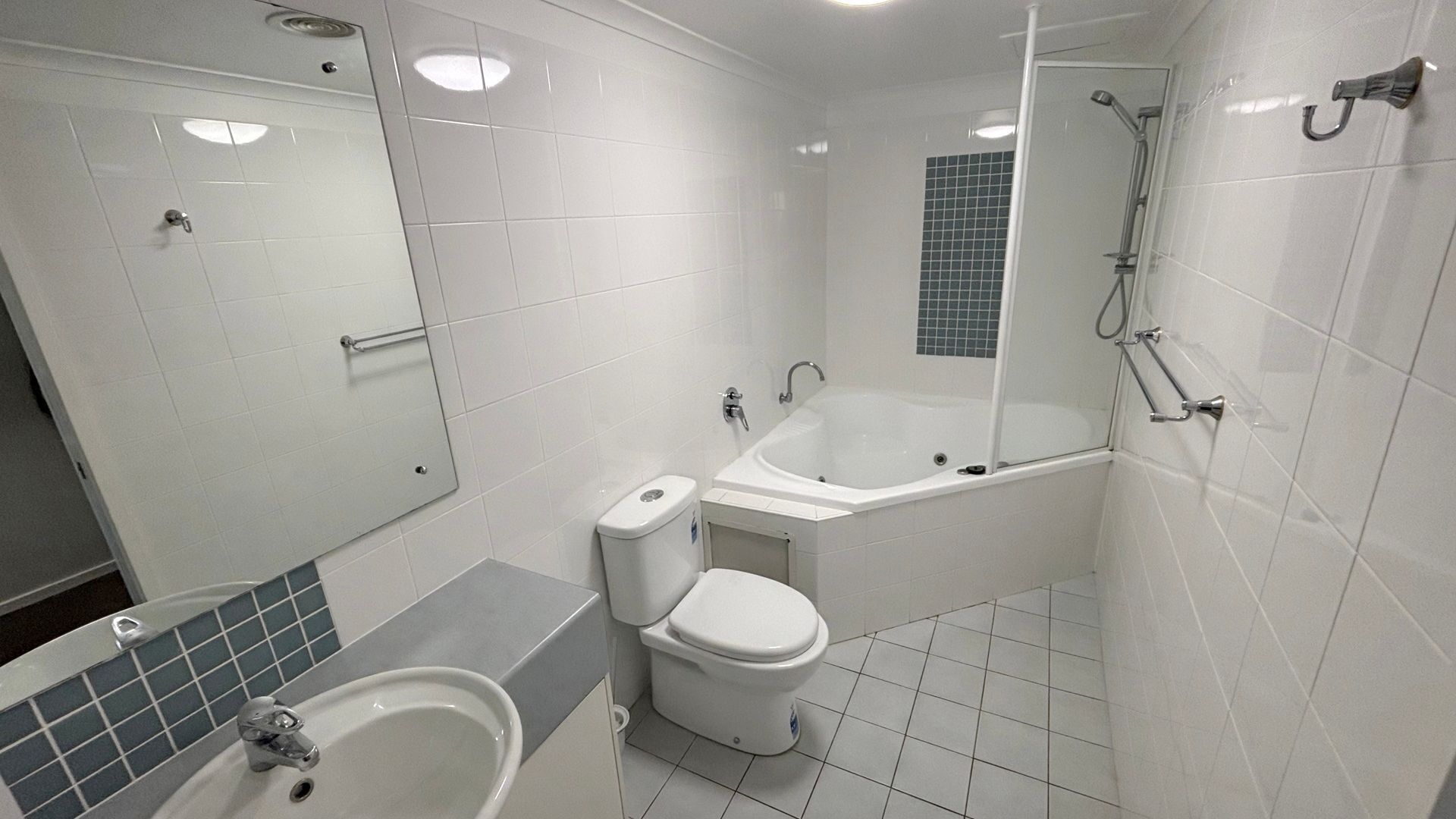 A modern bathroom with a bathtub, toilet, and sink.