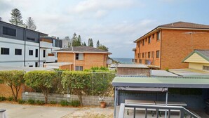 Een woonwijk met moderne huizen, uitzicht op zee en een omheind gazon.