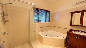 A bathroom with a glass shower enclosure, a bathtub, a vanity with a mirror, and a window with blinds. - Captains Cottage SWR (SOUTH WEST ROCKS)