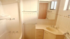 Ein Badezimmer mit Badewanne, Waschbecken, Spiegel und Handtuchhalter.