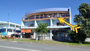 Stroll along the street to this charming building, featuring a bakery and restaurant below, with a balcony above.