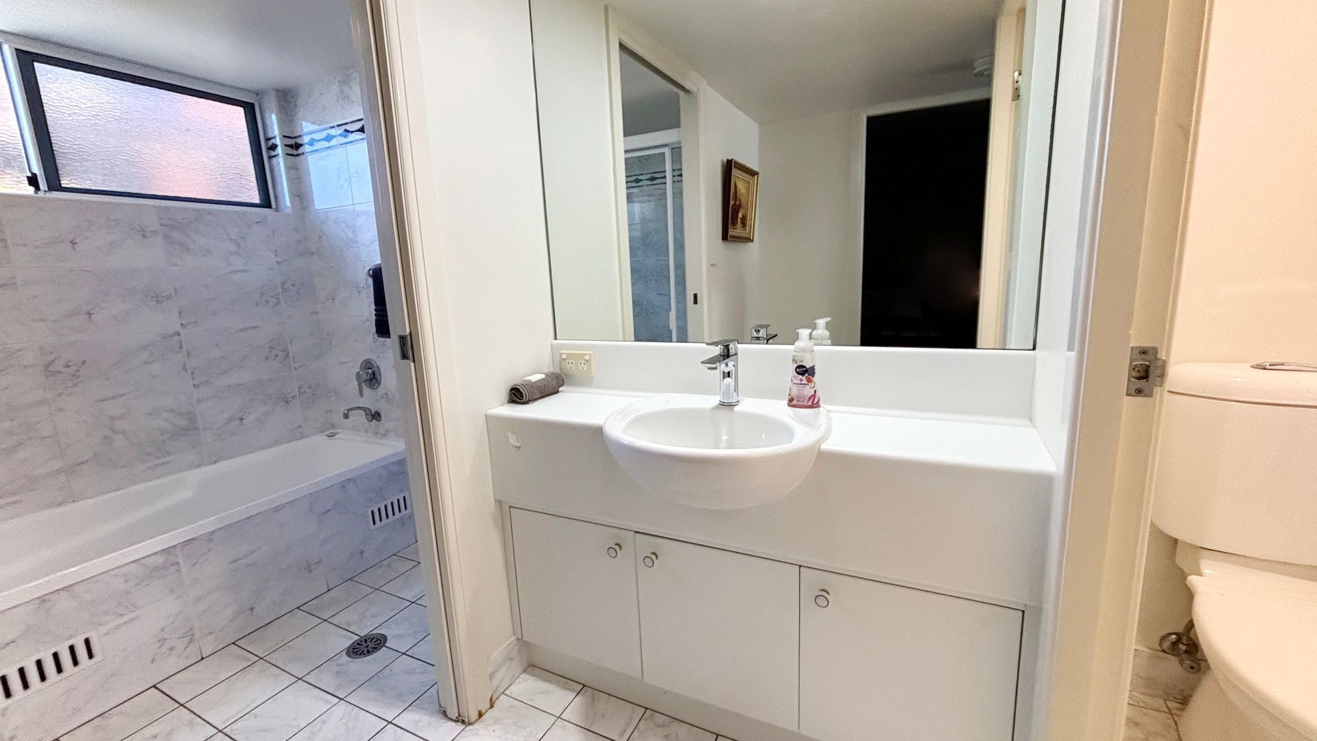 A bathroom with a bathtub, a sink, and a toilet.