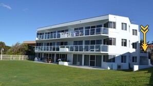 A modern multi-story building with balconies, large windows, and a flat roof. - Ocean Shores Apartment 13 (SOUTH WEST ROCKS)